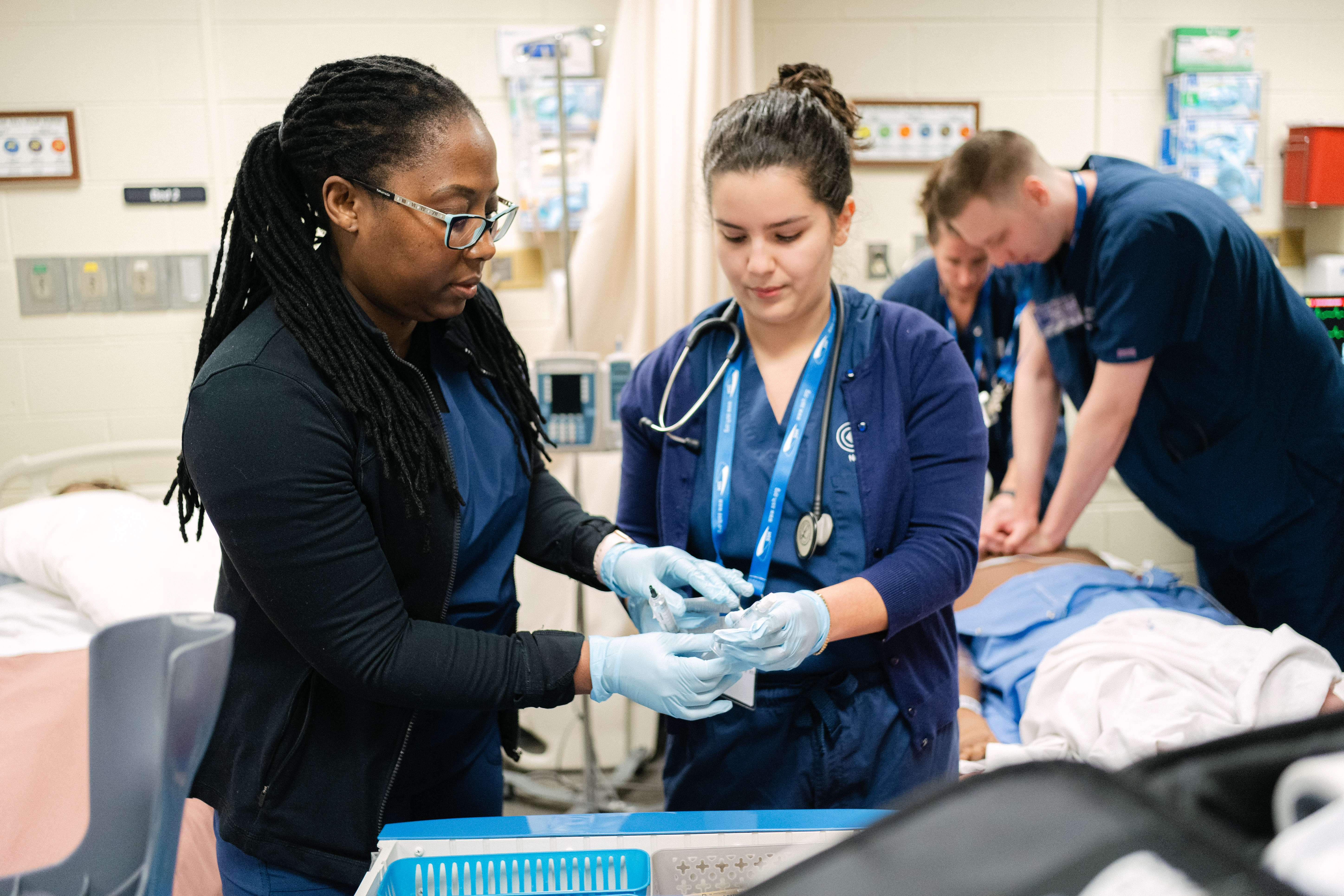 Two college nursing students working together in a nursing lab.